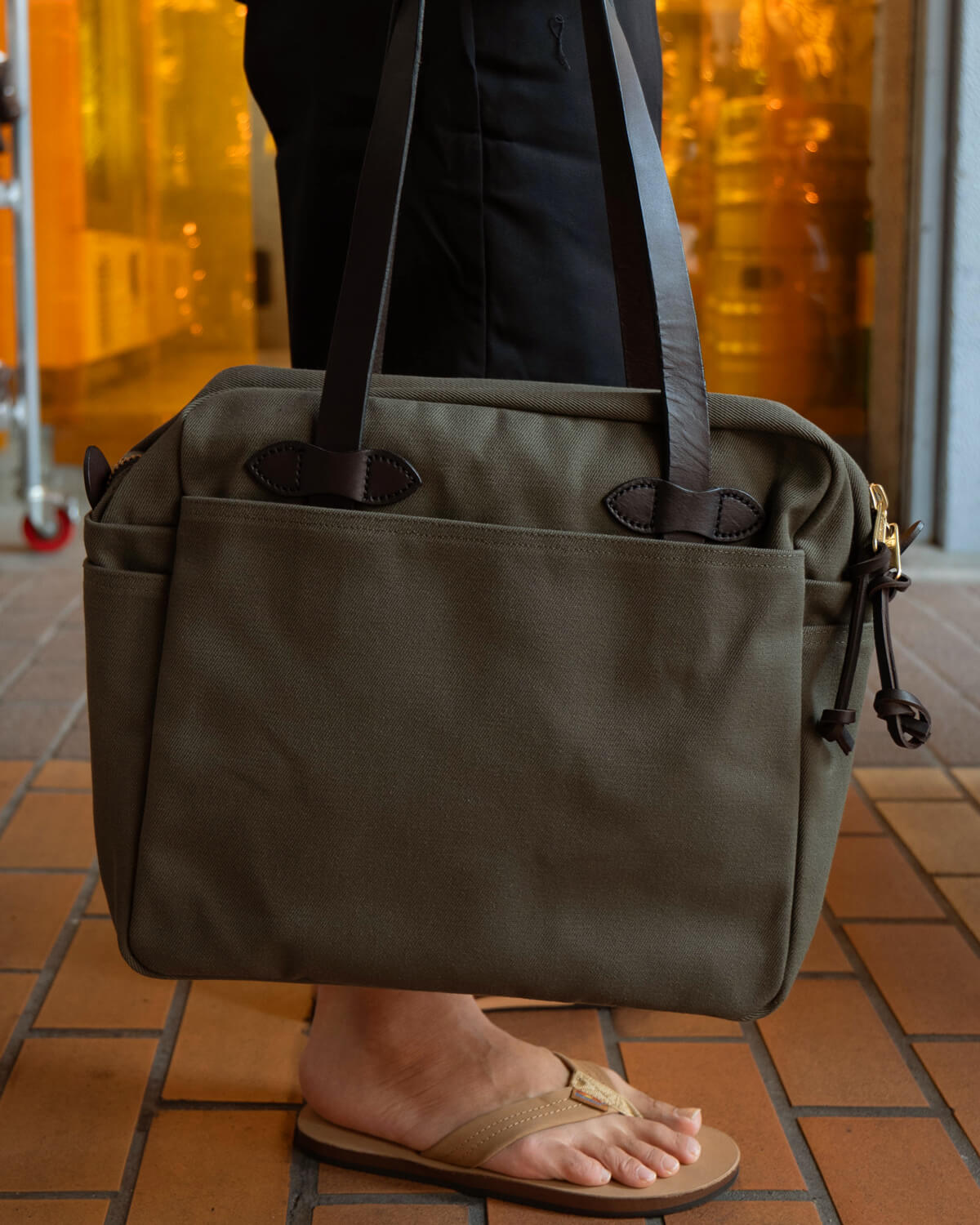 フィルソンのジップ付きトートバッグを手持ちしたシーンカット